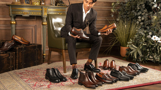 Man in a suit surrounded by different types of dress shoes, seemingly trying to choose a pair to wear
