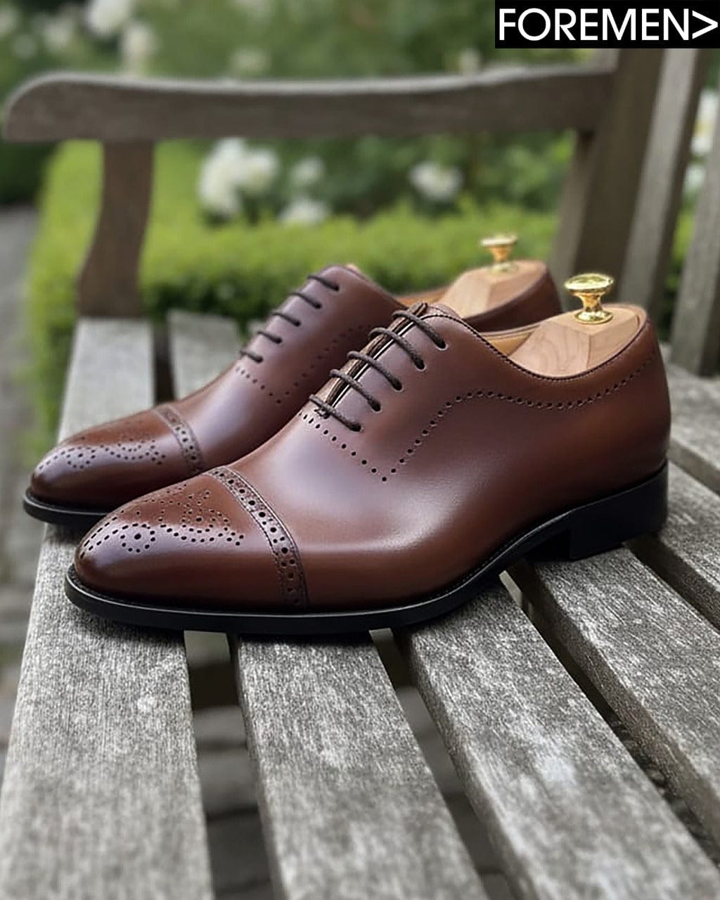 Brown leather shoes on a wooden bench with 'FOREMEN' branding.